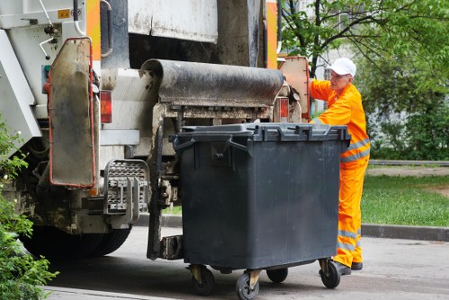 Recycling bins and segregated waste materials next to a skip